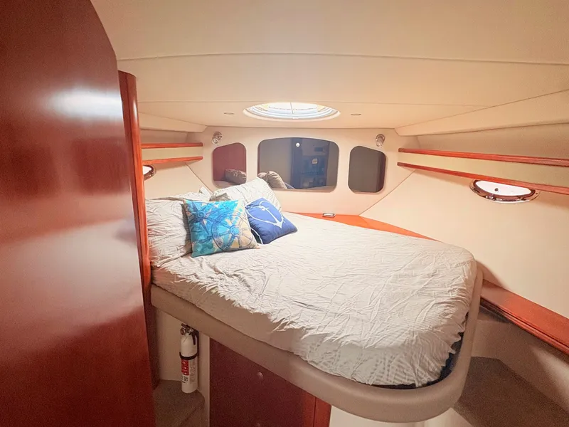 Slide: The Image of The cabin of a 2007 Cruisers 37O Express with a cozy bed and wooden accents. - 26