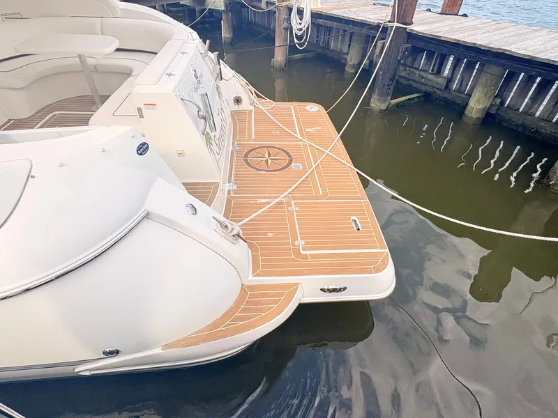 Slide: The Image of The image shows the stern of a 2007 Cruisers 37O Express with a wooden swim platform. - 8