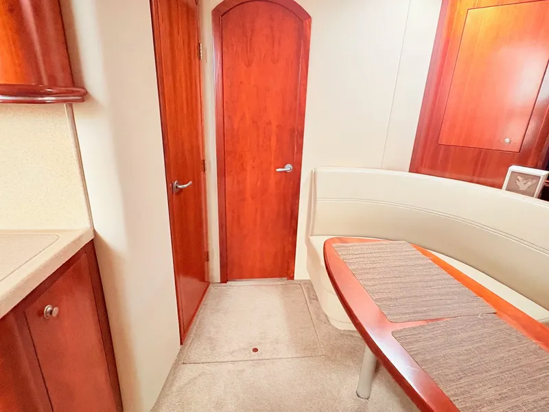 Slide: The Image of The interior cabin of a 2007 Cruisers 37O Express features a curved seating area and wooden doors. - 24