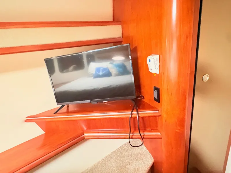 Slide: The Image of A cozy interior with a flat-screen TV on a wooden table, surrounded by warm wood tones. - 31