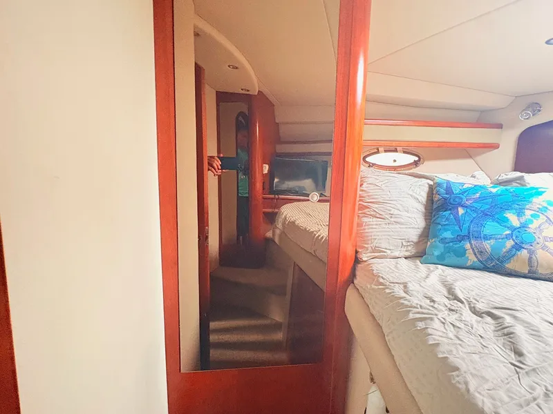 Slide: The Image of The cabin of a 2007 Cruisers 37O Express with a cozy bed and a mirror. - 28