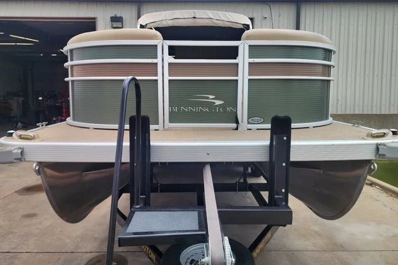 Slide: The Image of 2018 Bennington SSX21 pontoon boat on trailer, parked outside a building. - 3