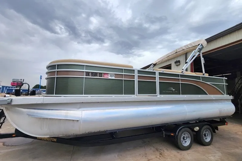 The Image of 2018 Bennington SSX21 pontoon boat on trailer, parked outdoors under cloudy sky. - 1