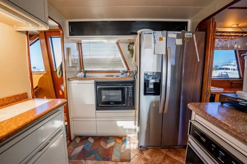 Slide: The Image of Interior of 1989 Viking 63 Motor Yacht kitchen with modern appliances and wood accents. - 22