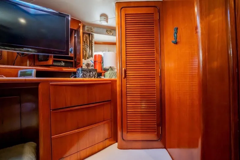 Slide: The Image of Interior of 1989 Viking 63 Motor Yacht with wooden cabinetry and TV. - 17