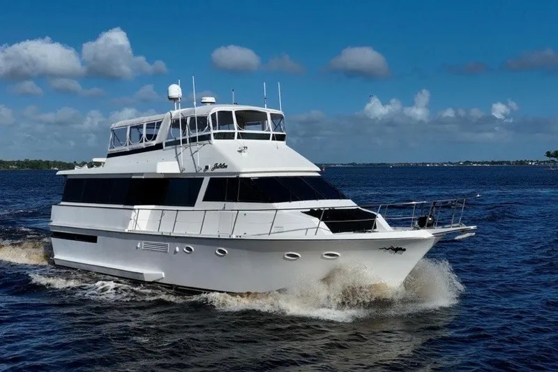 Slide: The Image of 1989 Viking 63 Motor Yacht cruising on open water under a clear blue sky. - 2