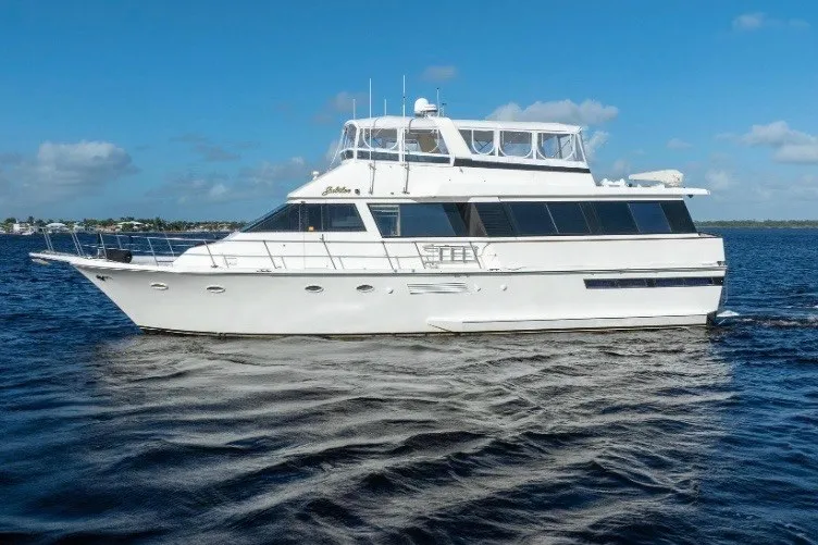 Slide: The Image of 1989 Viking 63 Motor Yacht cruising on open water under a clear blue sky. - 1