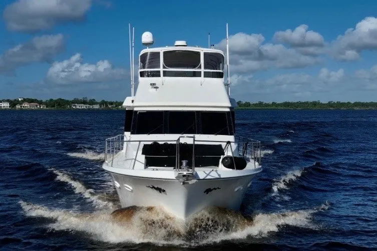 Slide: The Image of 1989 Viking 63 Motor Yacht cruising on open water under a clear blue sky. - 4