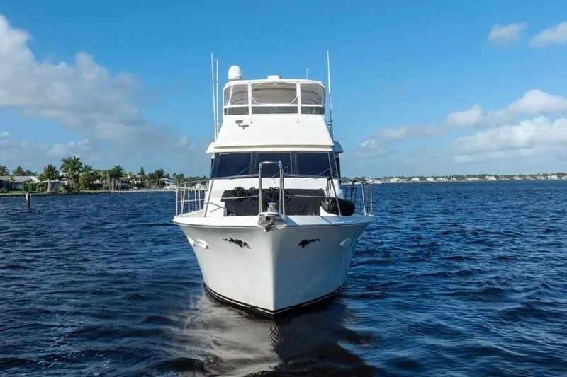 Slide: The Image of 1989 Viking 63 Motor Yacht on open water under clear blue sky. - 5