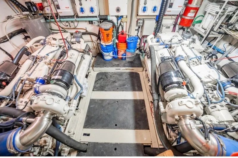 Slide: The Image of Engine room of a 1989 Viking 63 Motor Yacht with dual engines and maintenance supplies. - 32