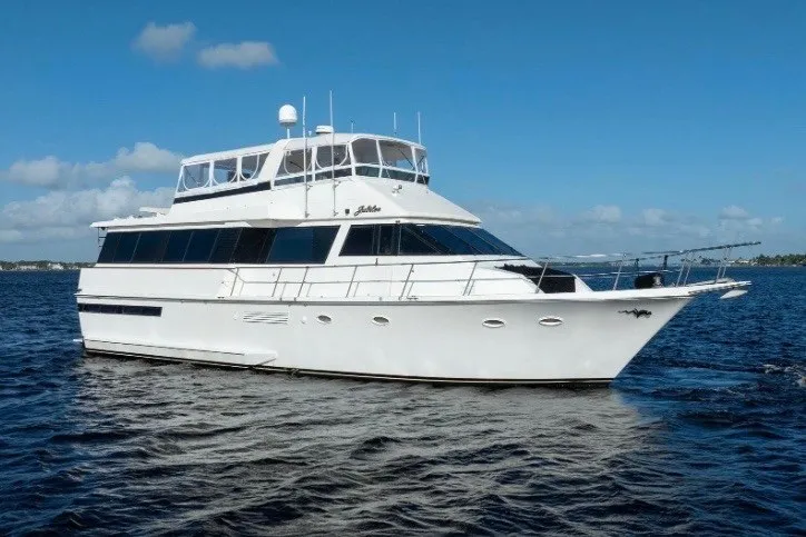 Slide: The Image of 1989 Viking 63 Motor Yacht cruising on open water under clear blue skies. - 3