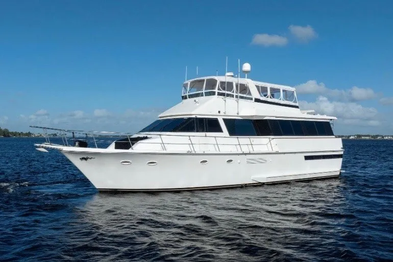 The Image of 1989 Viking 63 Motor Yacht cruising on open water under clear blue skies. - 0