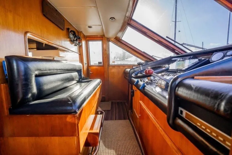 Slide: The Image of Interior helm of 1989 Viking 63 Motor Yacht with leather seating and wooden accents. - 25