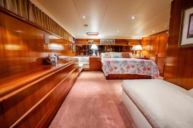Slide: The Image of Luxurious bedroom interior of a 1989 Viking 63 Motor Yacht with wood paneling and cozy decor. - 9