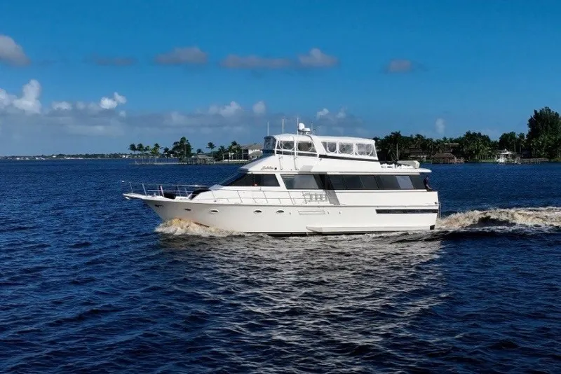 Slide: The Image of 1989 Viking 63 Motor Yacht cruising on a sunny day, surrounded by blue water. - 8