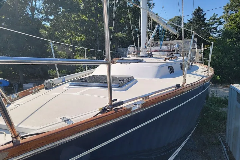 Slide: The Image of 2002 Tartan 3700 sailboat with sleek deck design, docked outdoors in sunny weather. - 32