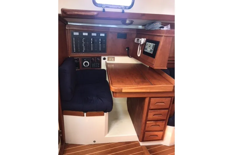 Slide: The Image of Interior of 2002 Tartan 3700 sailboat with navigation station and wooden cabinetry. - 13