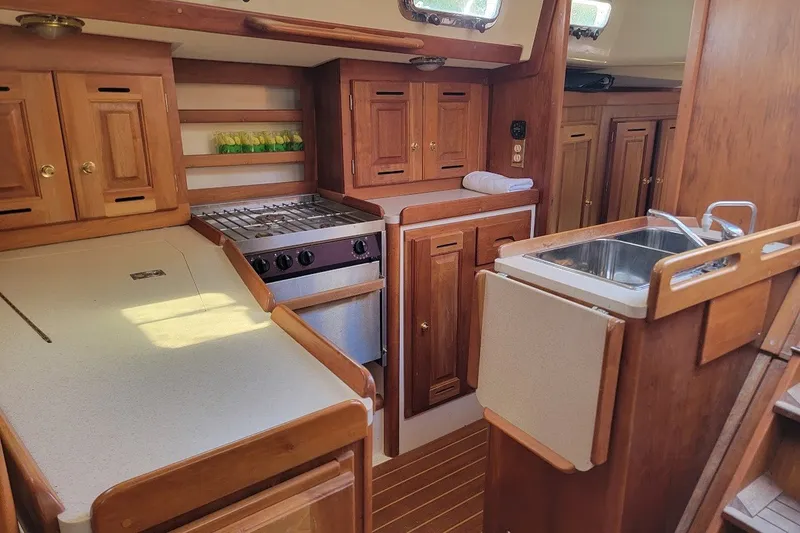Slide: The Image of Wooden interior of a 2002 Tartan 3700 yacht kitchen with stove and sink. - 6