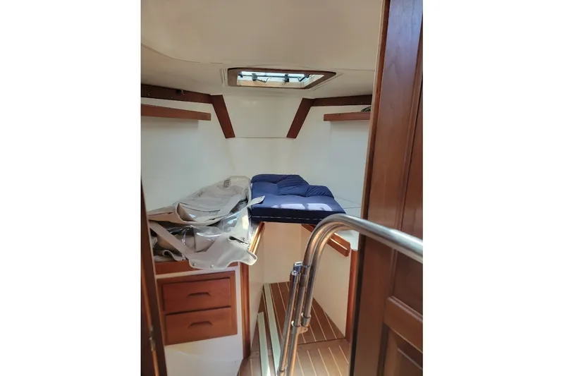 Slide: The Image of Cozy cabin interior of 2002 Tartan 3700 sailboat with wooden accents and bedding. - 5