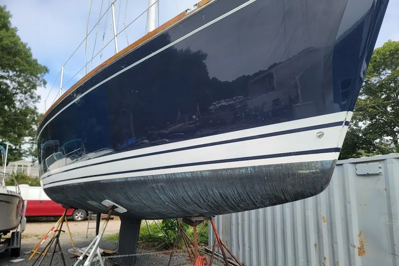Slide: The Image of 2002 Tartan 3700 sailboat hull on stands, blue and white design. - 24