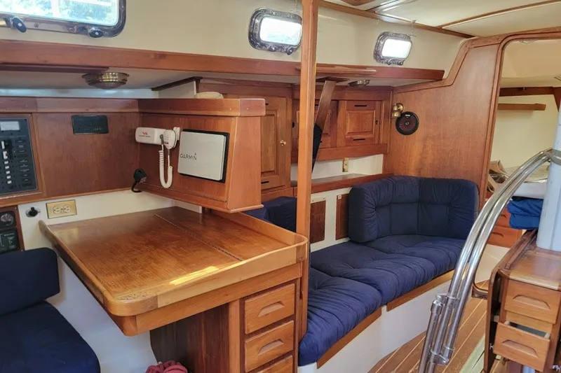 Slide: The Image of Interior of a 2002 Tartan 3700 sailboat with wooden furnishings and blue seating. - 4