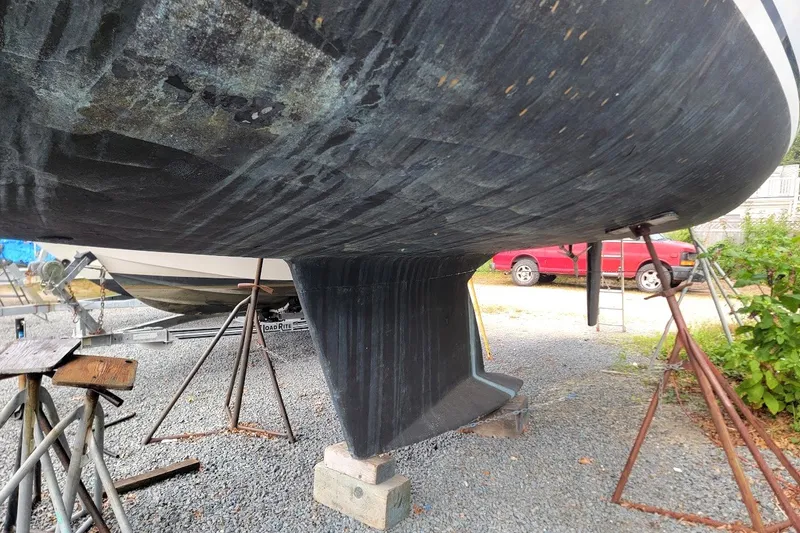 Slide: The Image of 2002 Tartan 3700 sailboat hull and keel on stands in a boatyard. - 31