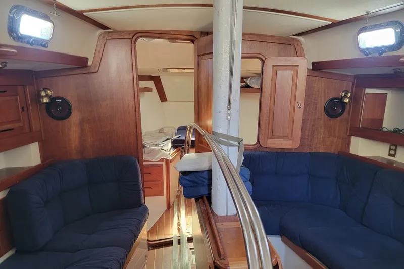 Slide: The Image of Interior of a 2002 Tartan 3700 sailboat with wooden furnishings and blue seating. - 20