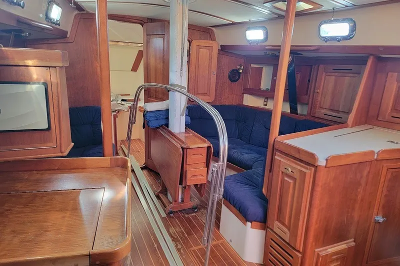 Slide: The Image of Interior of a 2002 Tartan 3700 sailboat with wooden furnishings and blue seating. - 23
