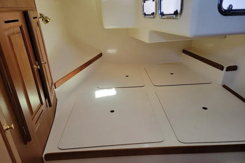 Slide: The Image of Interior cabin of a 2002 Tartan 3700 sailboat with wooden cabinets and storage compartments. - 9