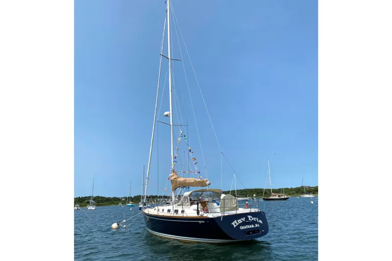 Slide: The Image of Sailboat Tartan 3700 (2002) anchored in a serene bay under clear blue skies. - 39