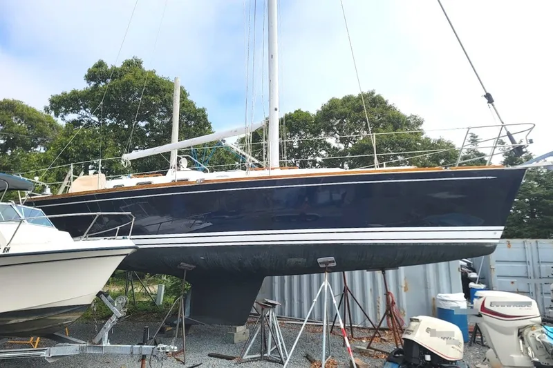 Slide: The Image of 2002 Tartan 3700 sailboat on dry dock, surrounded by trees and equipment. - 2
