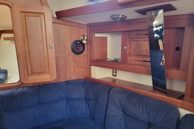 Slide: The Image of Cozy interior of 2002 Tartan 3700 sailboat with wood paneling and blue seating. - 21
