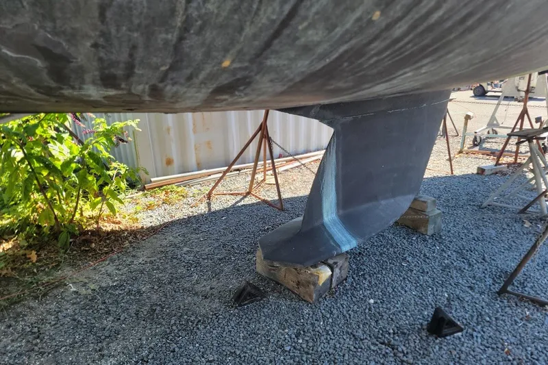 Slide: The Image of Tartan 3700 sailboat keel on gravel, supported by blocks, 2002 model. - 30