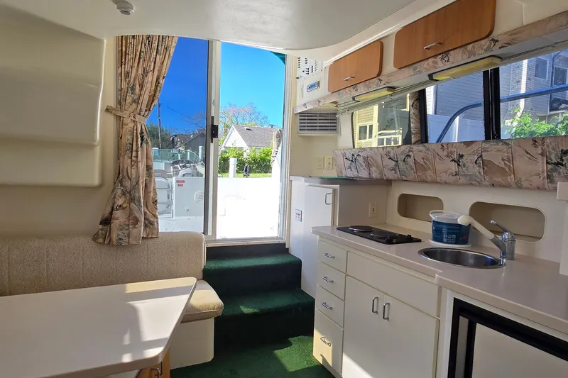 Slide: The Image of Interior of a 1995 Mainship 31 Sedan Bridge with kitchenette and seating area. - 32