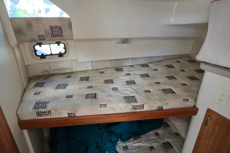 Slide: The Image of Interior cabin of 1995 Mainship 31 Sedan Bridge with patterned bedding and small window. - 29