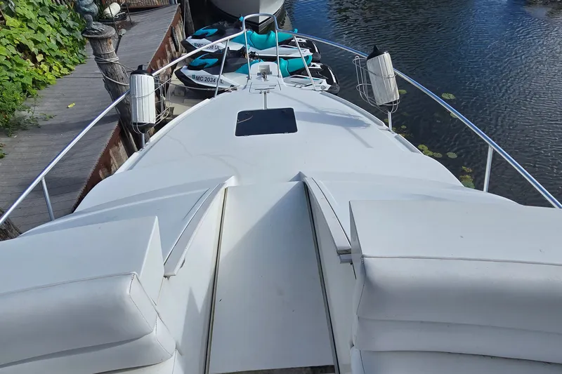 Slide: The Image of 1995 Mainship 31 Sedan Bridge boat docked, featuring spacious deck and sleek design. - 9