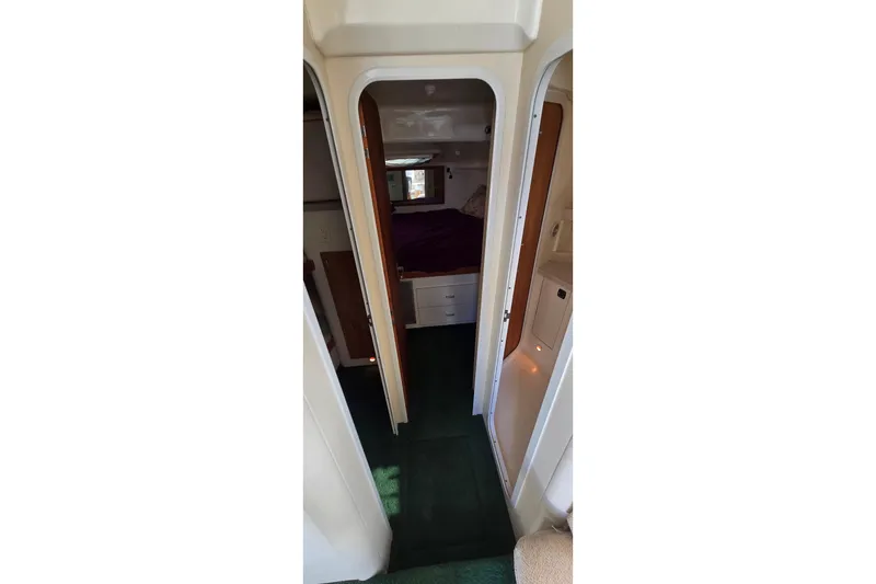 Slide: The Image of Interior view of 1995 Mainship 31 Sedan Bridge cabin with green carpet and cozy sleeping area. - 21