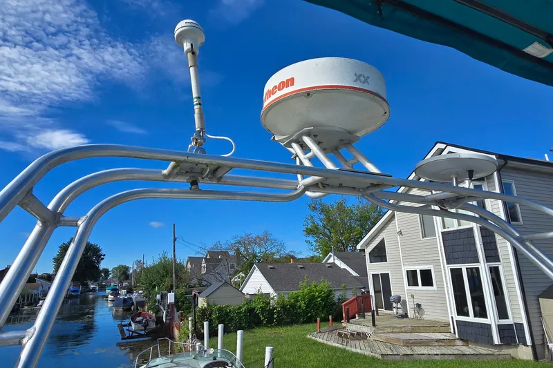 Slide: The Image of Radar equipment on a 1995 Mainship 31 Sedan Bridge, with waterfront homes in the background. - 15