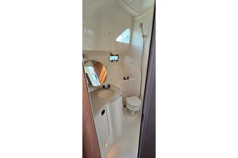 Slide: The Image of 1995 Mainship 31 Sedan Bridge bathroom with sink, toilet, and showerhead. - 28