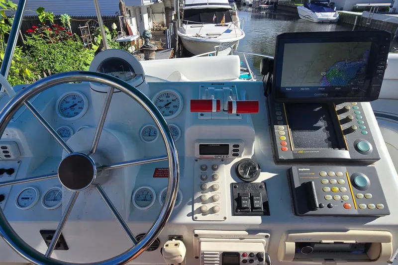 Slide: The Image of 1995 Mainship 31 Sedan Bridge helm with steering wheel, gauges, and navigation equipment. - 12
