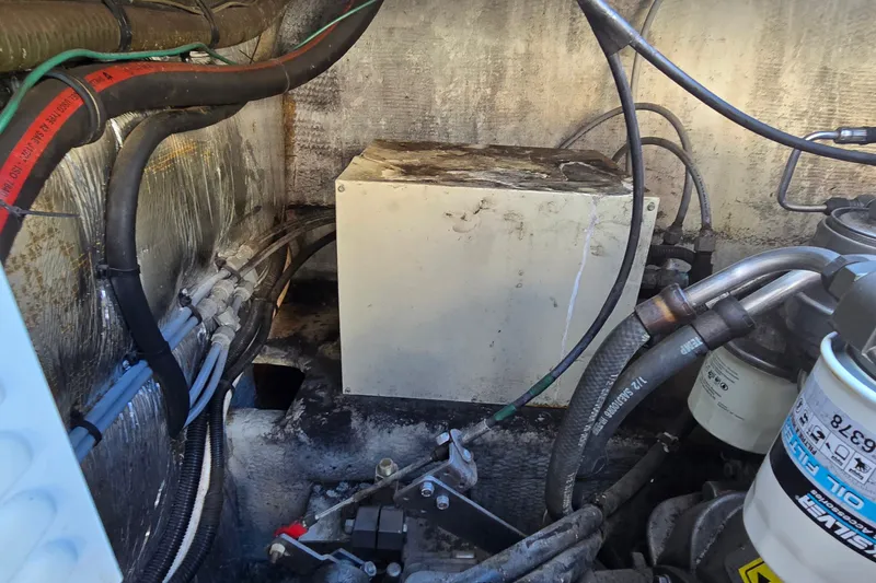 Slide: The Image of Engine compartment of a 1995 Mainship 31 Sedan Bridge with visible hoses and components. - 37