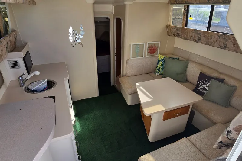 Slide: The Image of Interior of a 1995 Mainship 31 Sedan Bridge with cozy seating and kitchenette. - 18