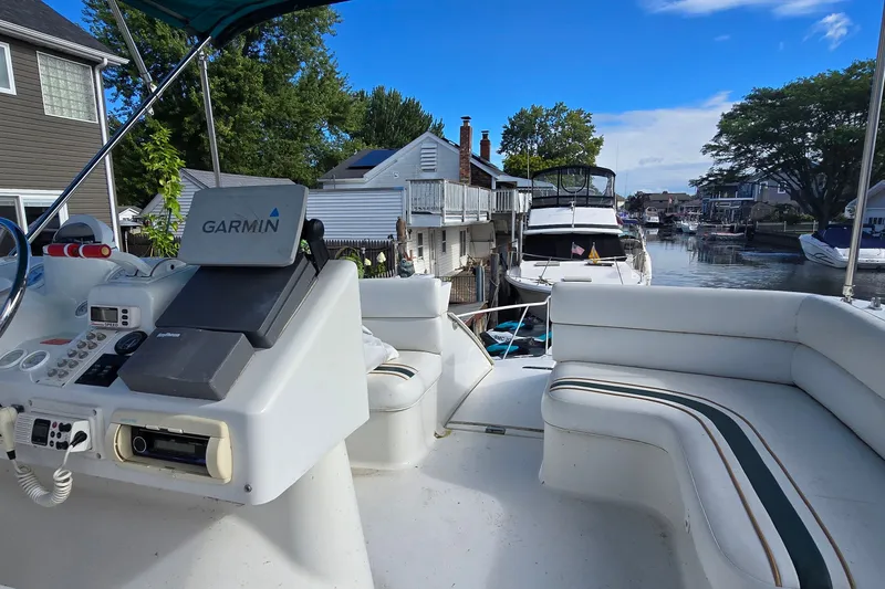 Slide: The Image of 1995 Mainship 31 Sedan Bridge boat with Garmin navigation, docked in a scenic canal setting. - 7