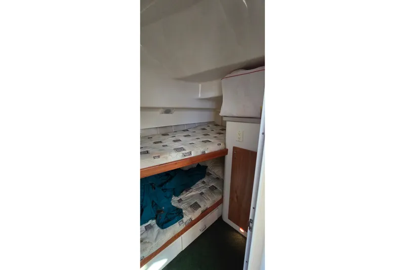 Slide: The Image of 1995 Mainship 31 Sedan Bridge cabin interior with bunk beds and storage. - 24