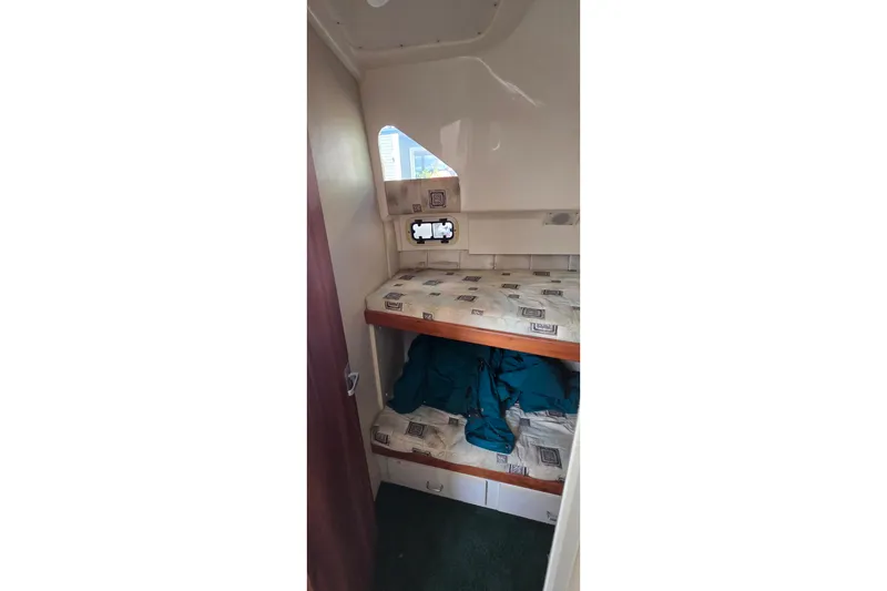 Slide: The Image of Interior cabin of 1995 Mainship 31 Sedan Bridge with bunk beds and small window. - 23