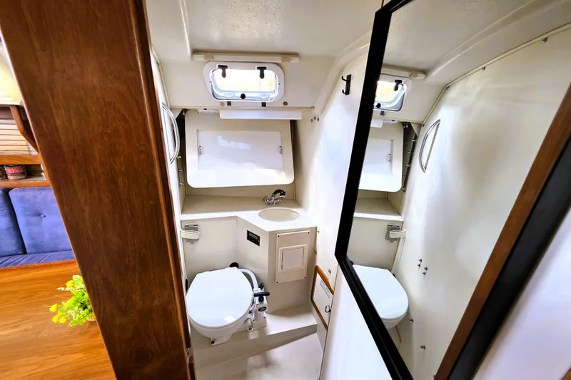 Slide: The Image of Interior of 1995 Catalina 30 MkIII sailboat bathroom with toilet, sink, and storage. - 10
