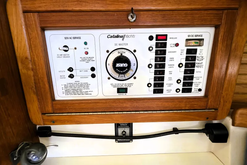 Slide: The Image of Electrical control panel of a 1995 Catalina 30 MkIII yacht, featuring AC and DC service switches. - 14