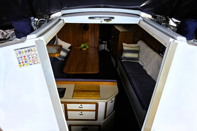 Slide: The Image of Interior of a 1995 Catalina 30 MkIII sailboat, featuring cozy seating and a wooden table. - 2