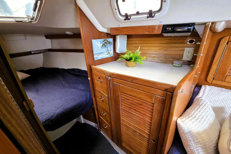 Slide: The Image of Cozy interior of a 1995 Catalina 30 MkIII sailboat with wooden cabinetry and a comfortable bed. - 9