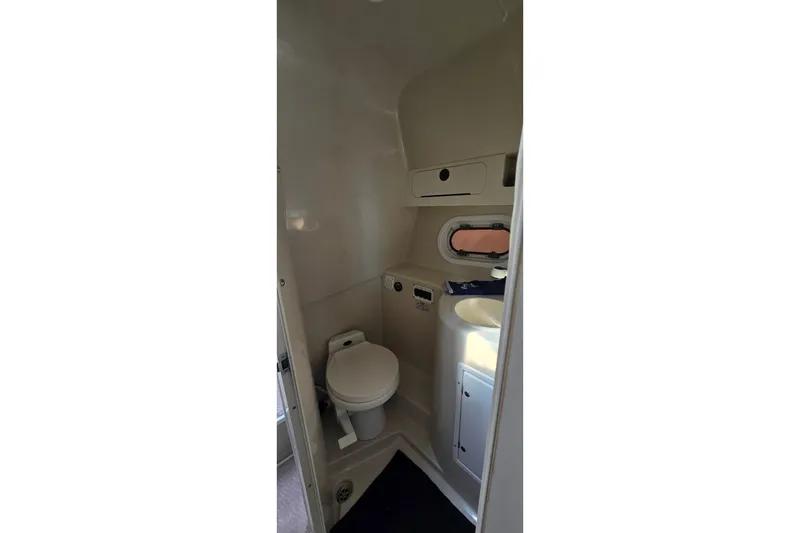 Slide: The Image of Compact bathroom in 2000 Four Winns 328 Vista boat, featuring toilet and sink. - 27